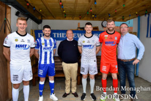 Players, HMT Director Gerard Magee and NCAFC Commercial Manager Gary Wilson